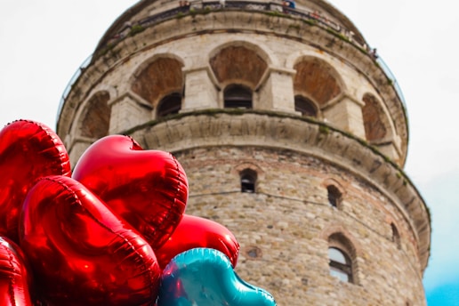 red heart balloons near brown concrete building during daytime