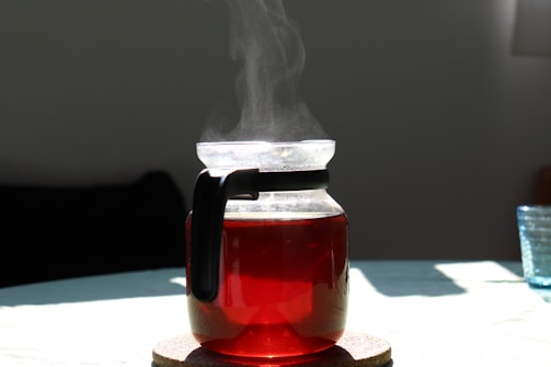 A stylish electric kettle glowing warmly next to a cup of tea