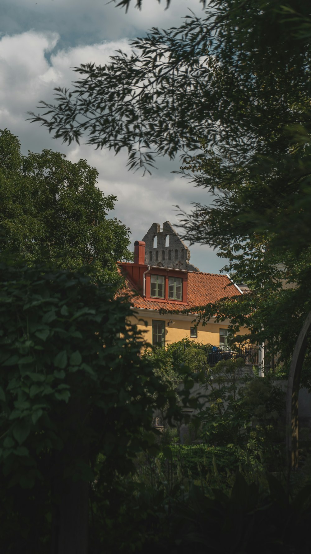 brown and white house surrounded by green trees