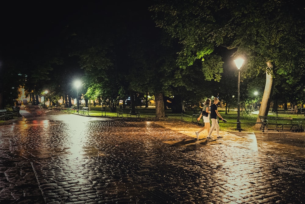 couple walking on the street during night time