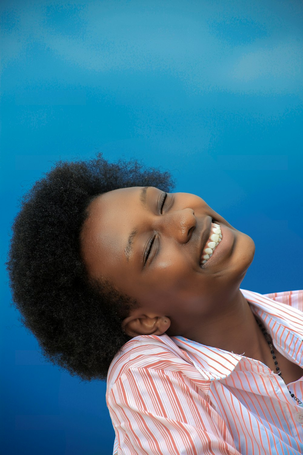 fille souriante en chemise à rayures roses et blanches