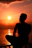 A serene image of a person sitting quietly by a calm lake at sunset, reflecting inwardly.