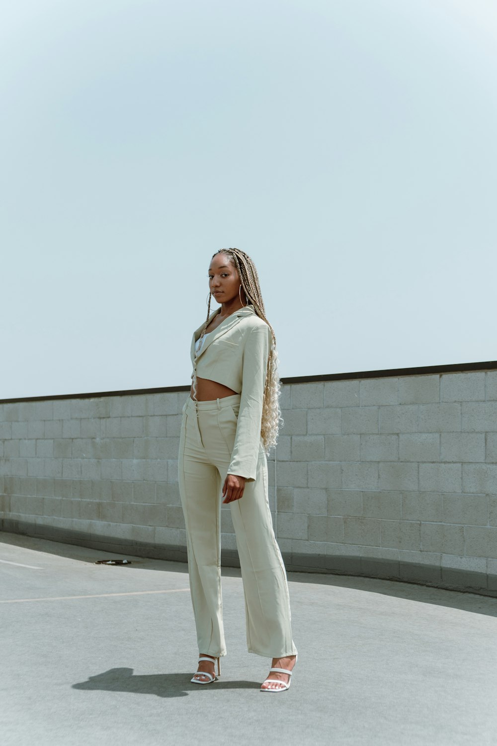 woman in white long sleeve shirt and white pants standing on white concrete floor
