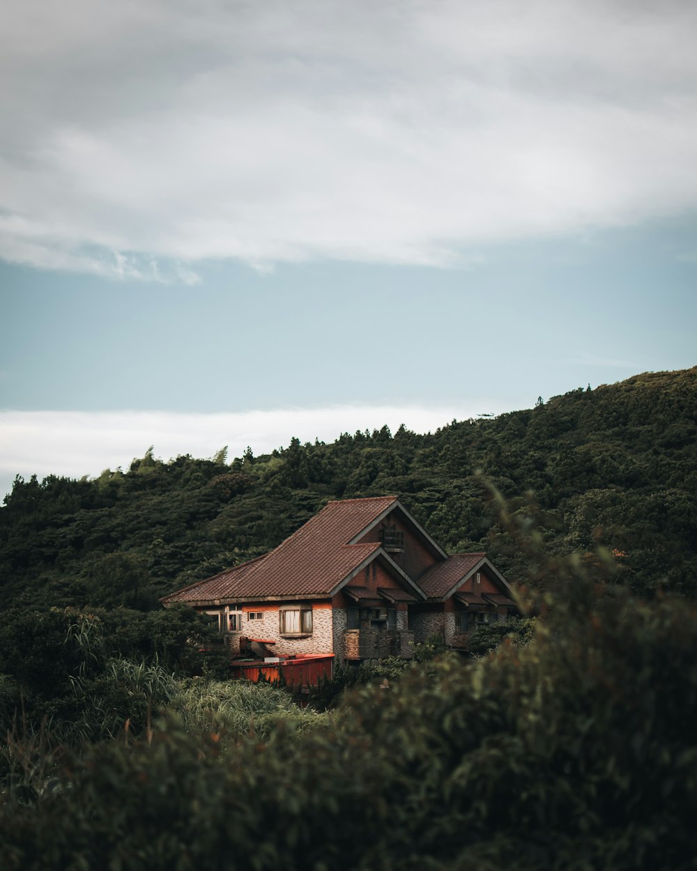 brown wooden house on green grass field under blue sky during daytime