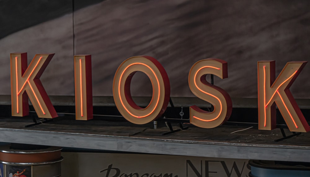 a close up of a neon sign that reads kiosk