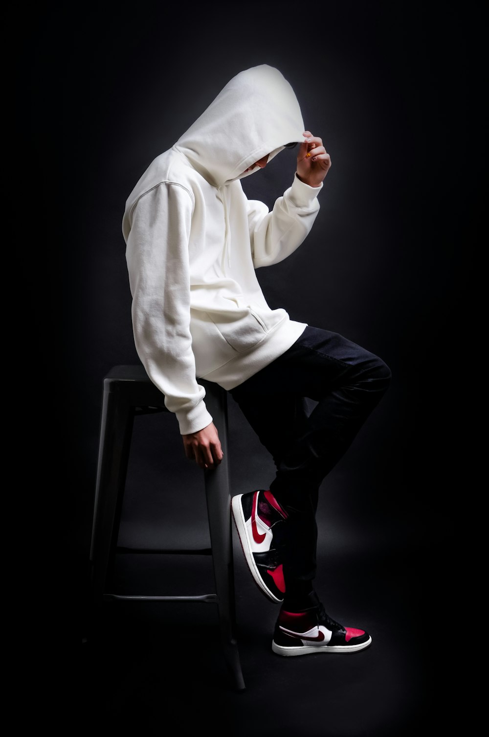 man in white long sleeve shirt and black pants sitting on black chair