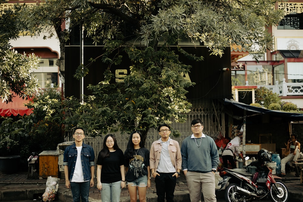 group of people standing near green tree during daytime