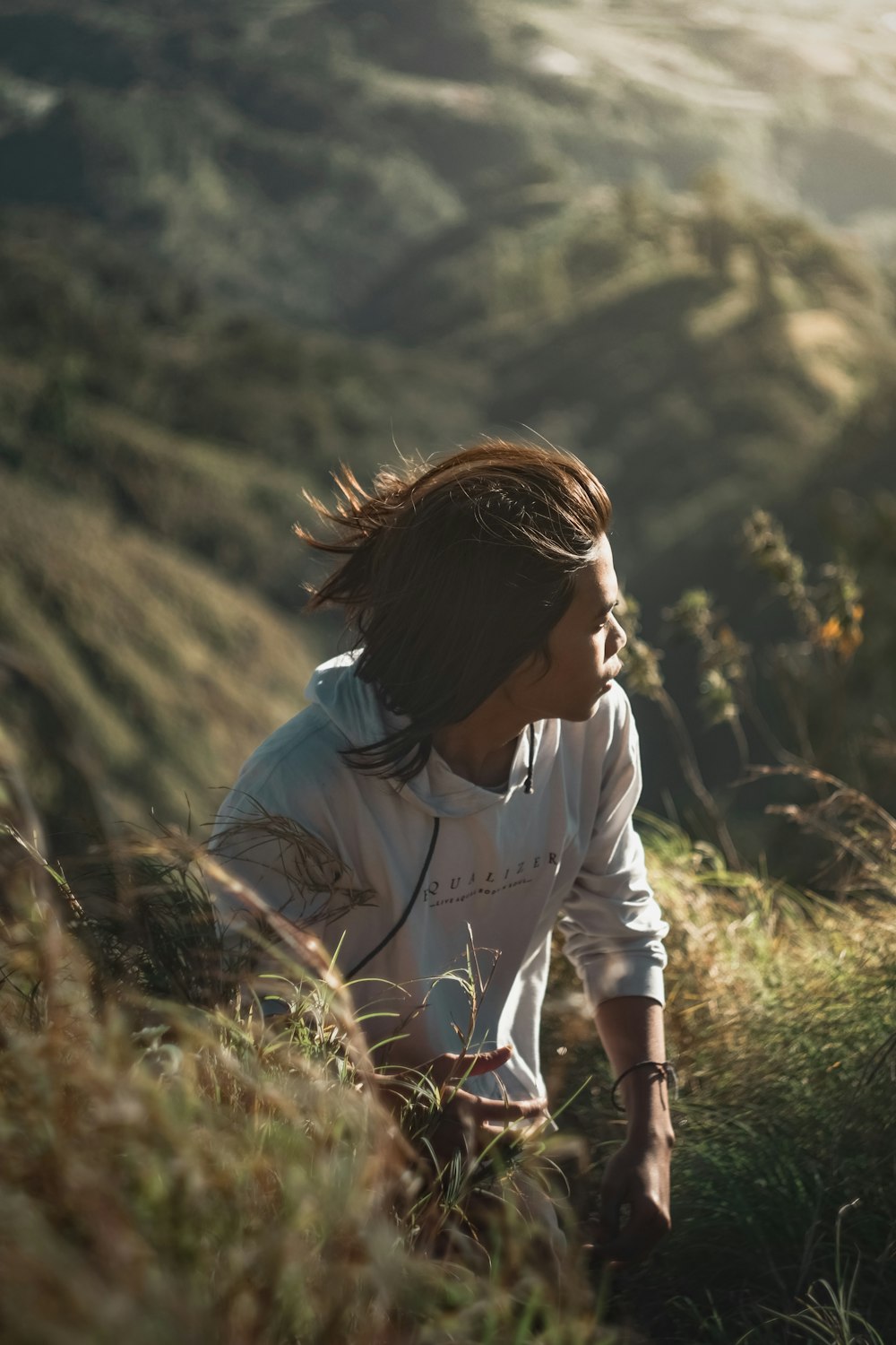 woman in white t-shirt standing on green grass field during daytime