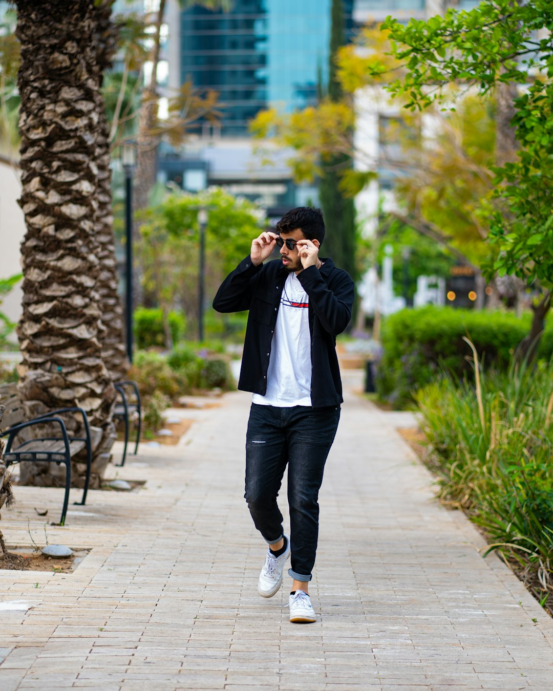 man in white dress shirt and black pants standing on sidewalk during daytime