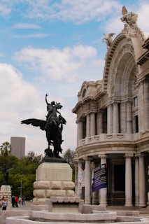 black horse statue near white concrete building during daytime