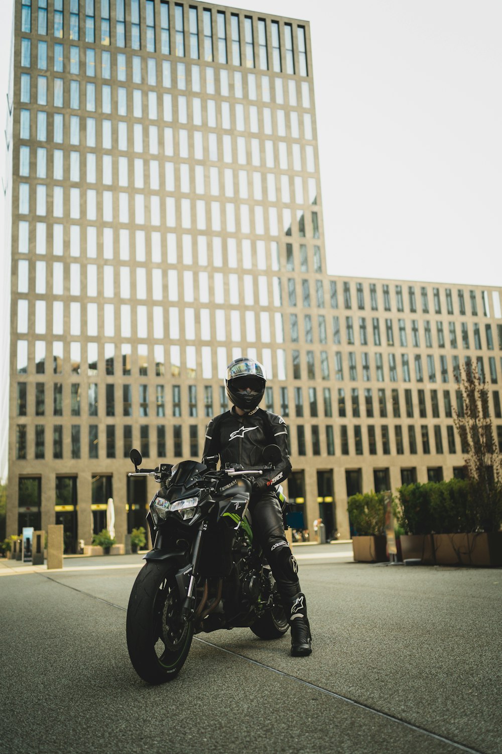 man in black leather jacket riding black motorcycle on road during daytime