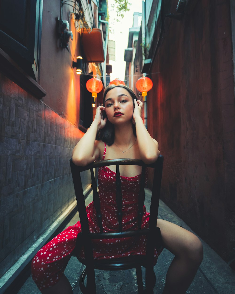 woman in black and red dress sitting on red and white floral area rug