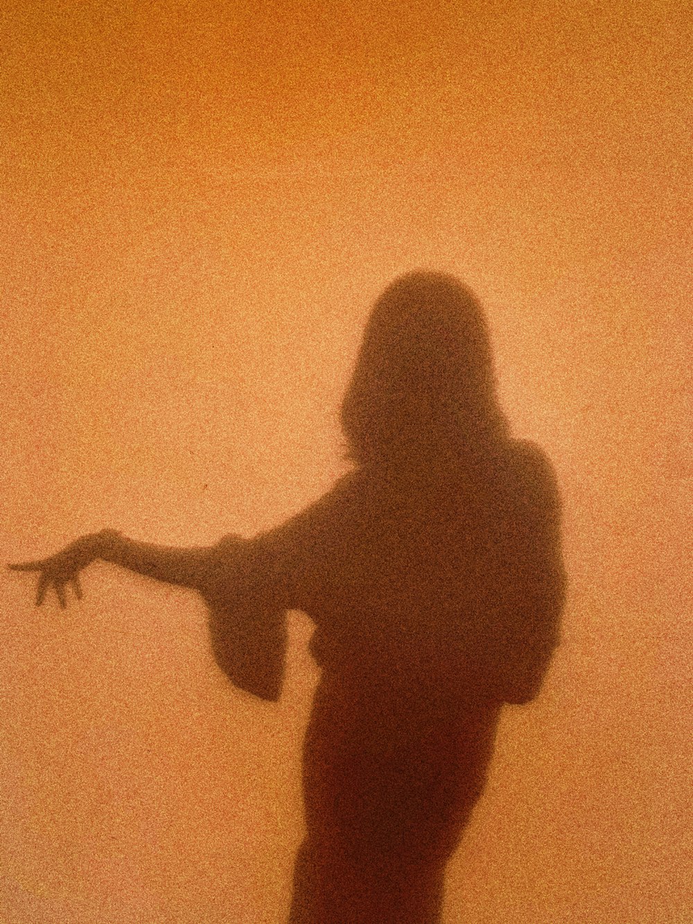 silhouette of woman standing and raising her right hand