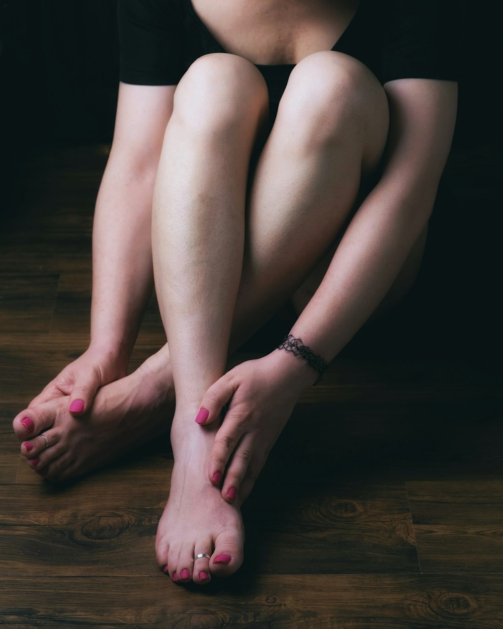 mulher em shorts pretos sentados no chão de madeira marrom