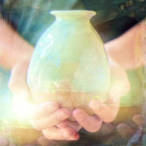 A close-up of a delicate hand-painted ceramic vase glowing softly under natural light.
