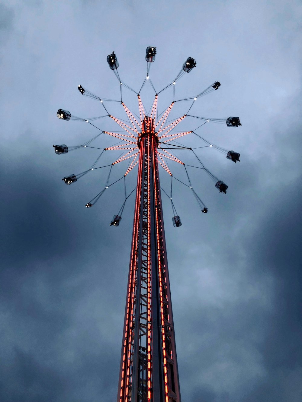 red and black metal tower under gray sky