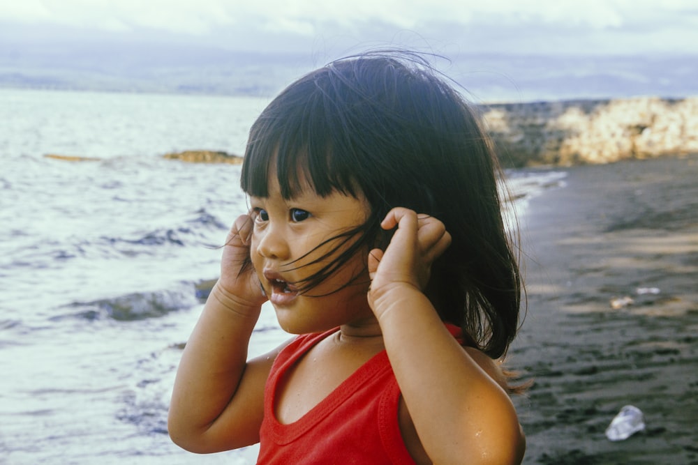 girl in red tank top covering her face with her hair