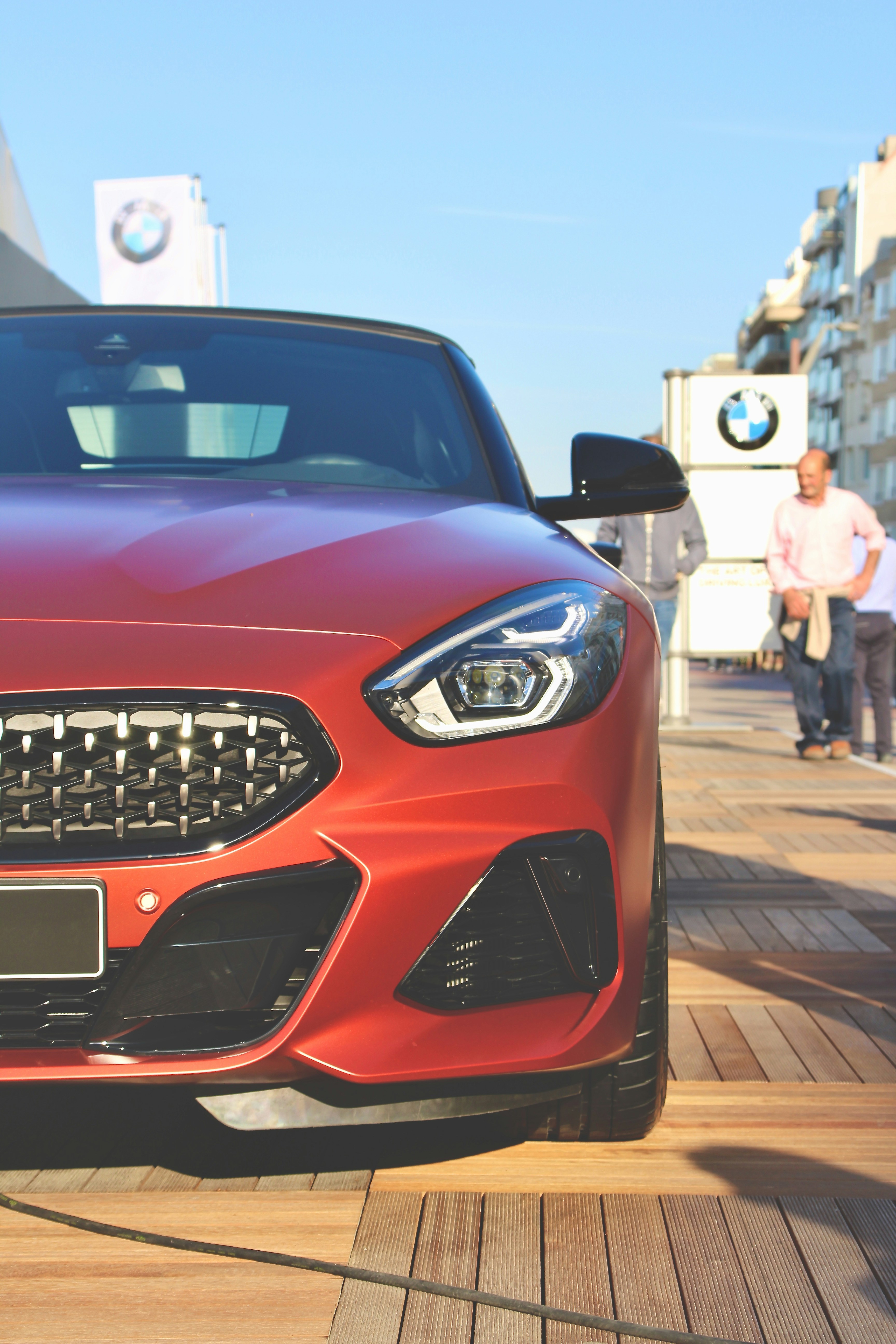red car parked on sidewalk during daytime