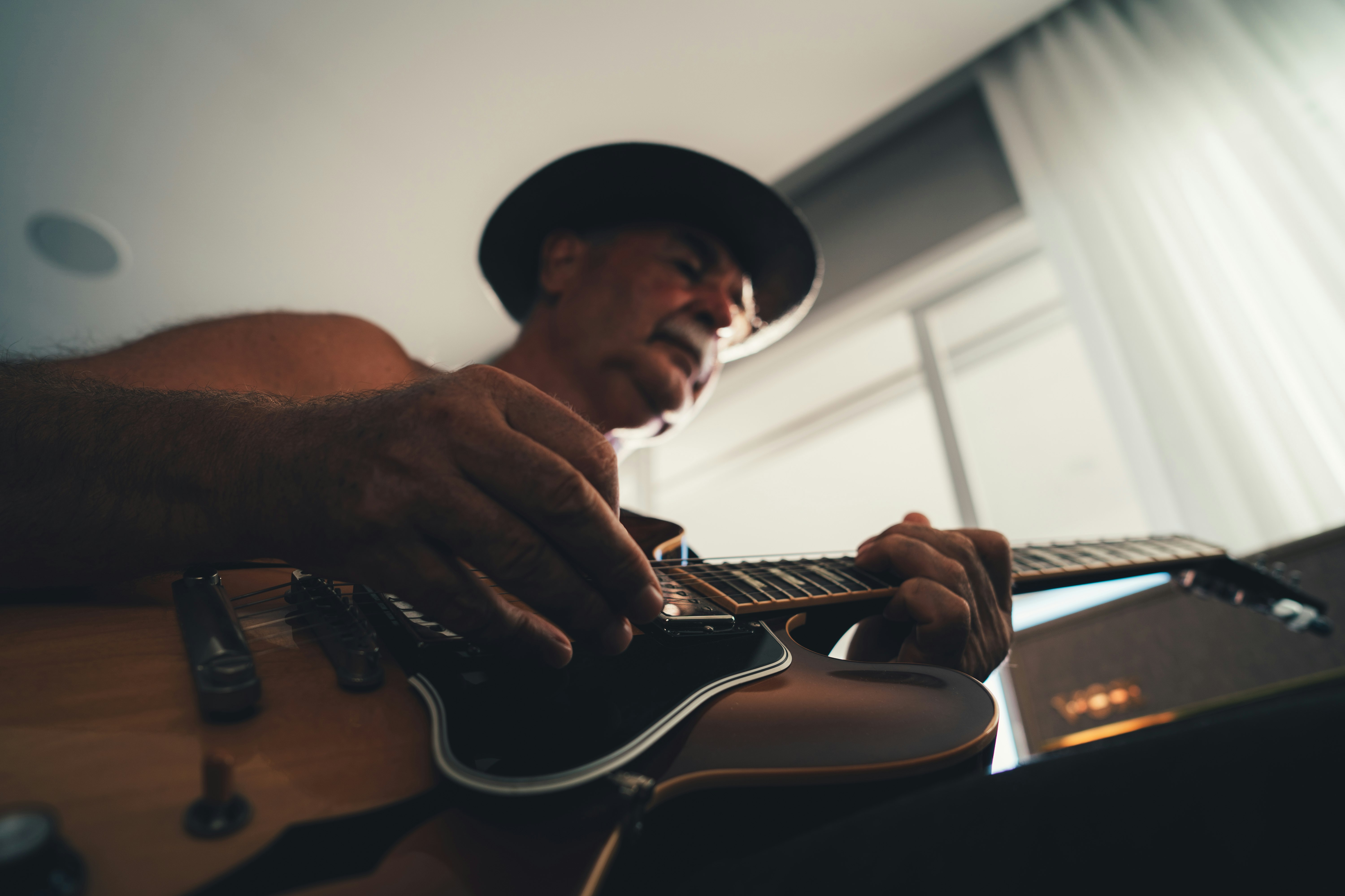 man playing brown acoustic guitar