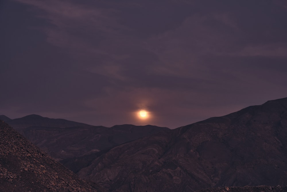 brown mountain under gray sky during sunset