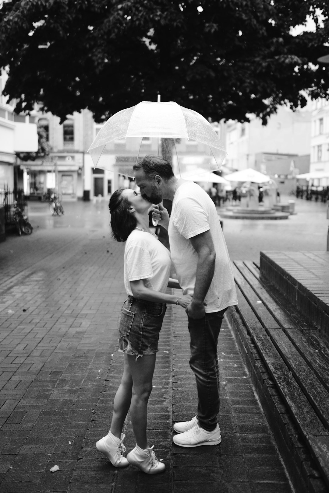 grayscale photo of couple walking on sidewalk