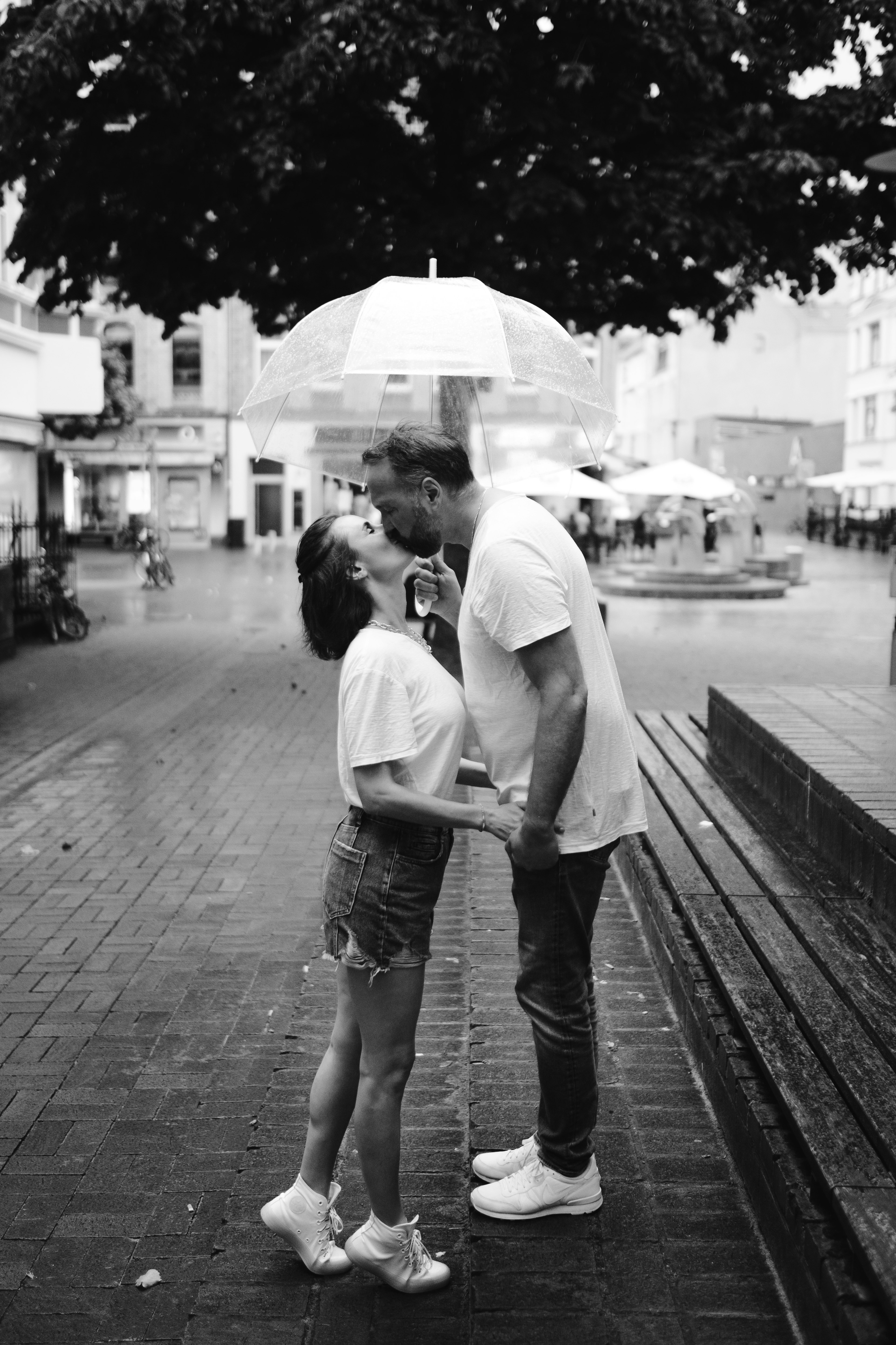 grayscale photo of couple walking on sidewalk