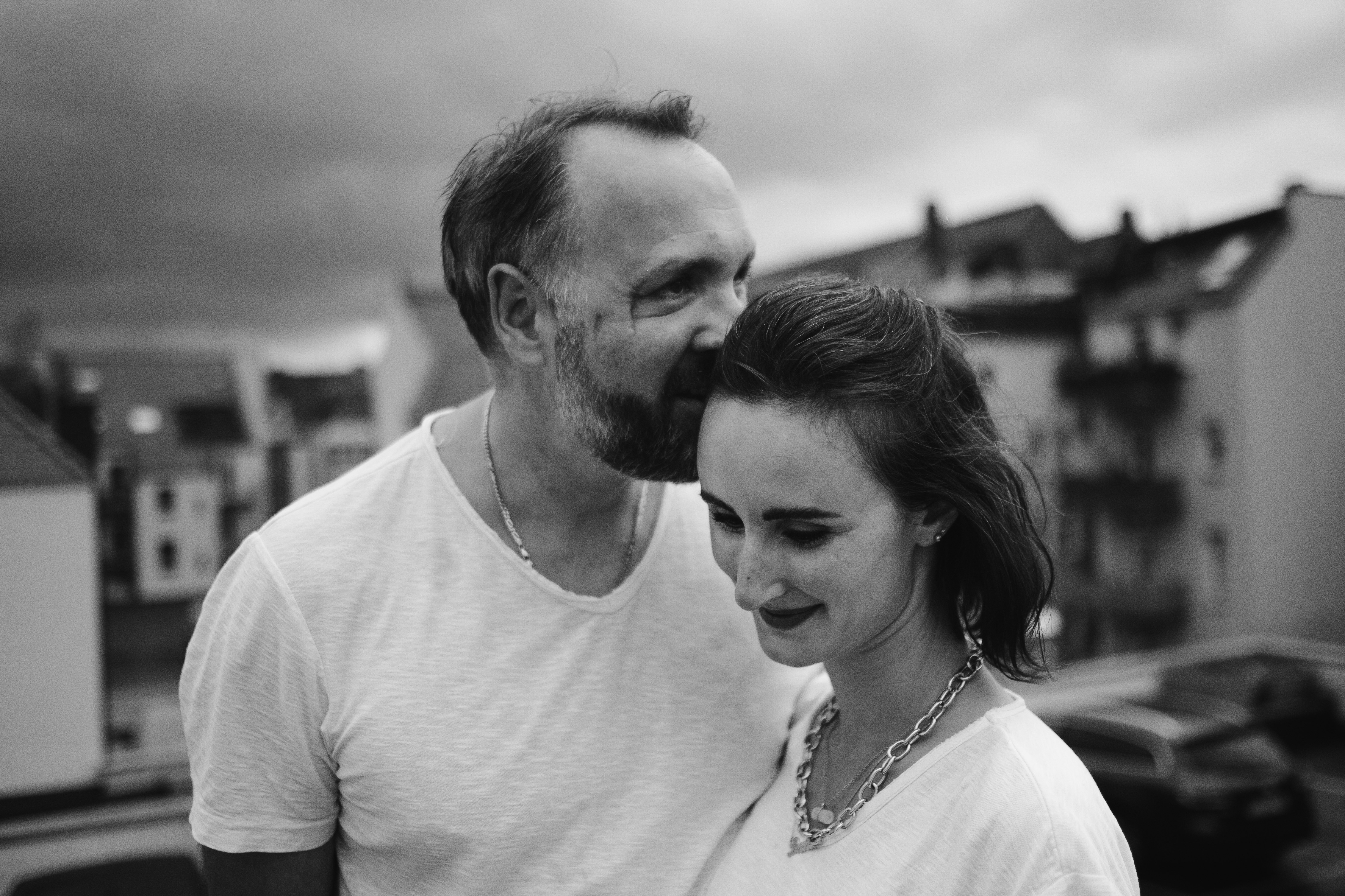 man in crew neck shirt kissing woman in white crew neck shirt