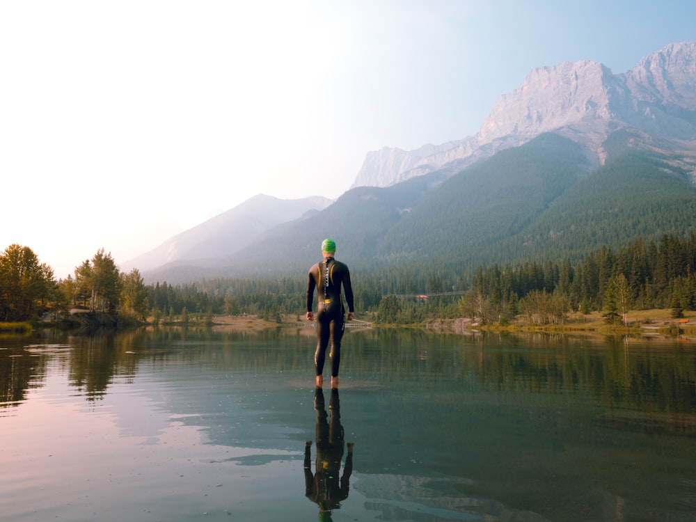 man in black jacket and black pants standing on water during daytime