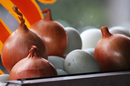 Close-up of golden onion flakes spread evenly on a rustic wooden surface.