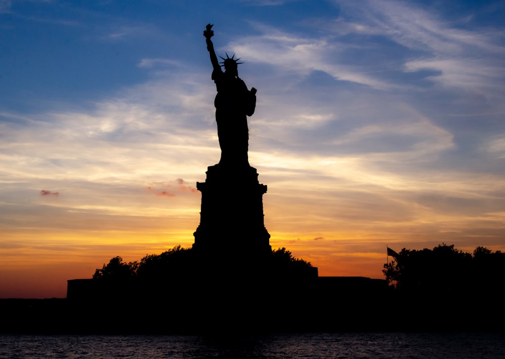 silhouette of statue of liberty during sunset