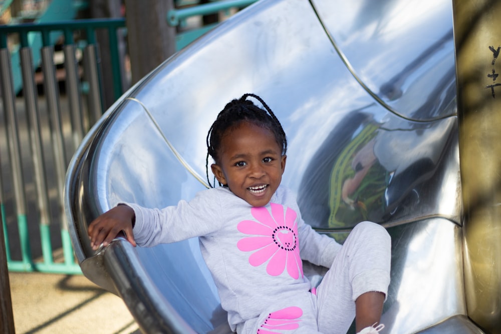 girl in pink and white long sleeve shirt sitting on blue and white round chair