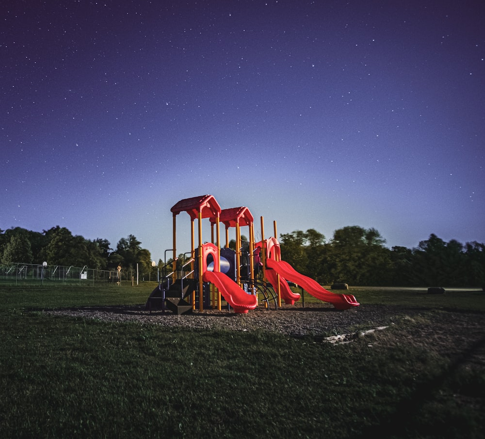 red and brown playground under blue sky during night time