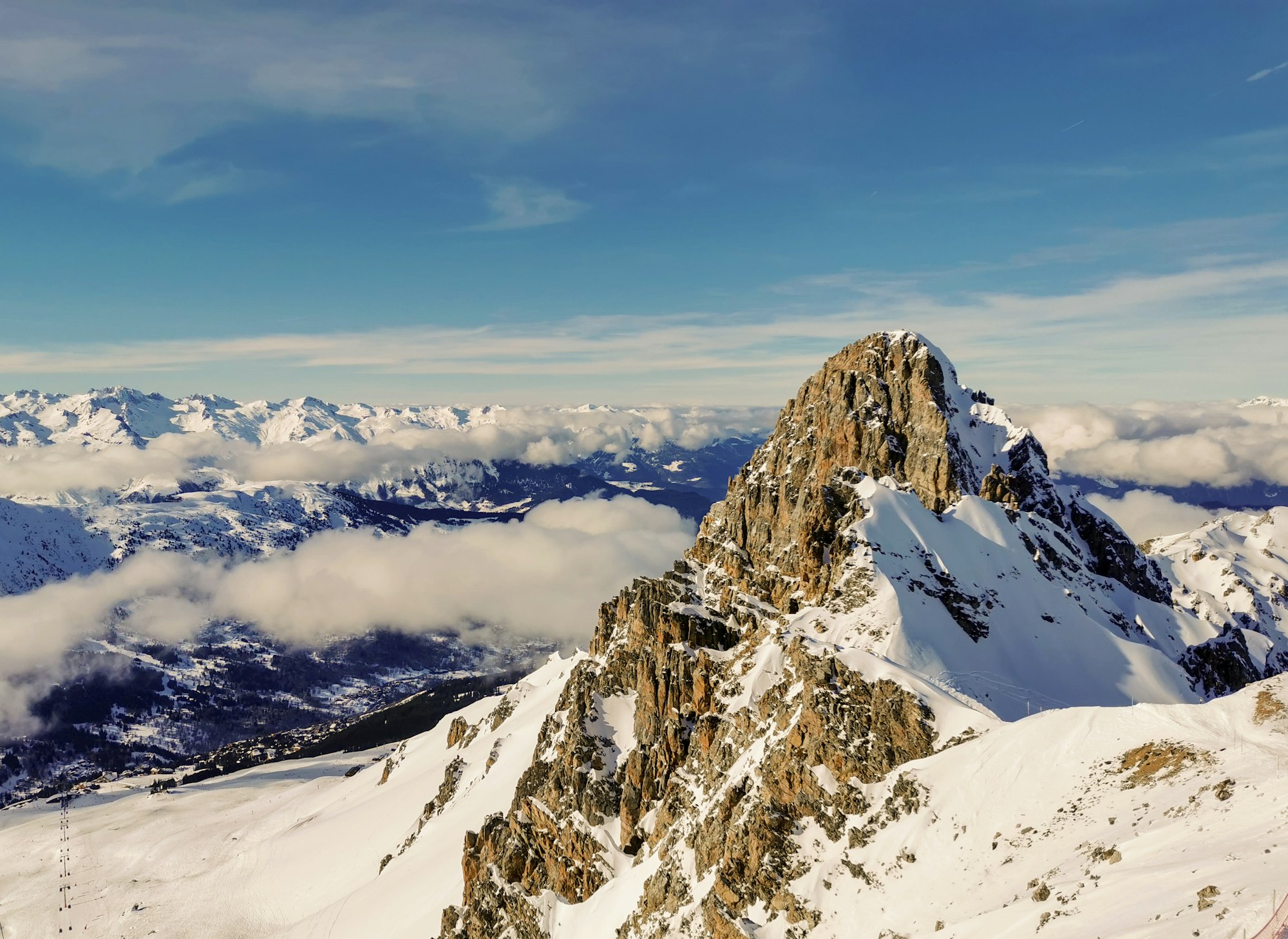 High snow-covered peaks above the clouds near the ski resort of Courchevel, France