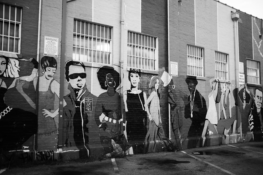 grayscale photo of 3 women standing near wall