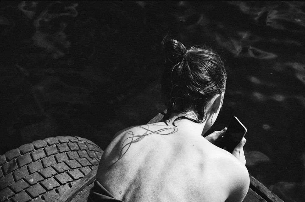 foto in scala di grigi di donna in top nero con spalline sottili