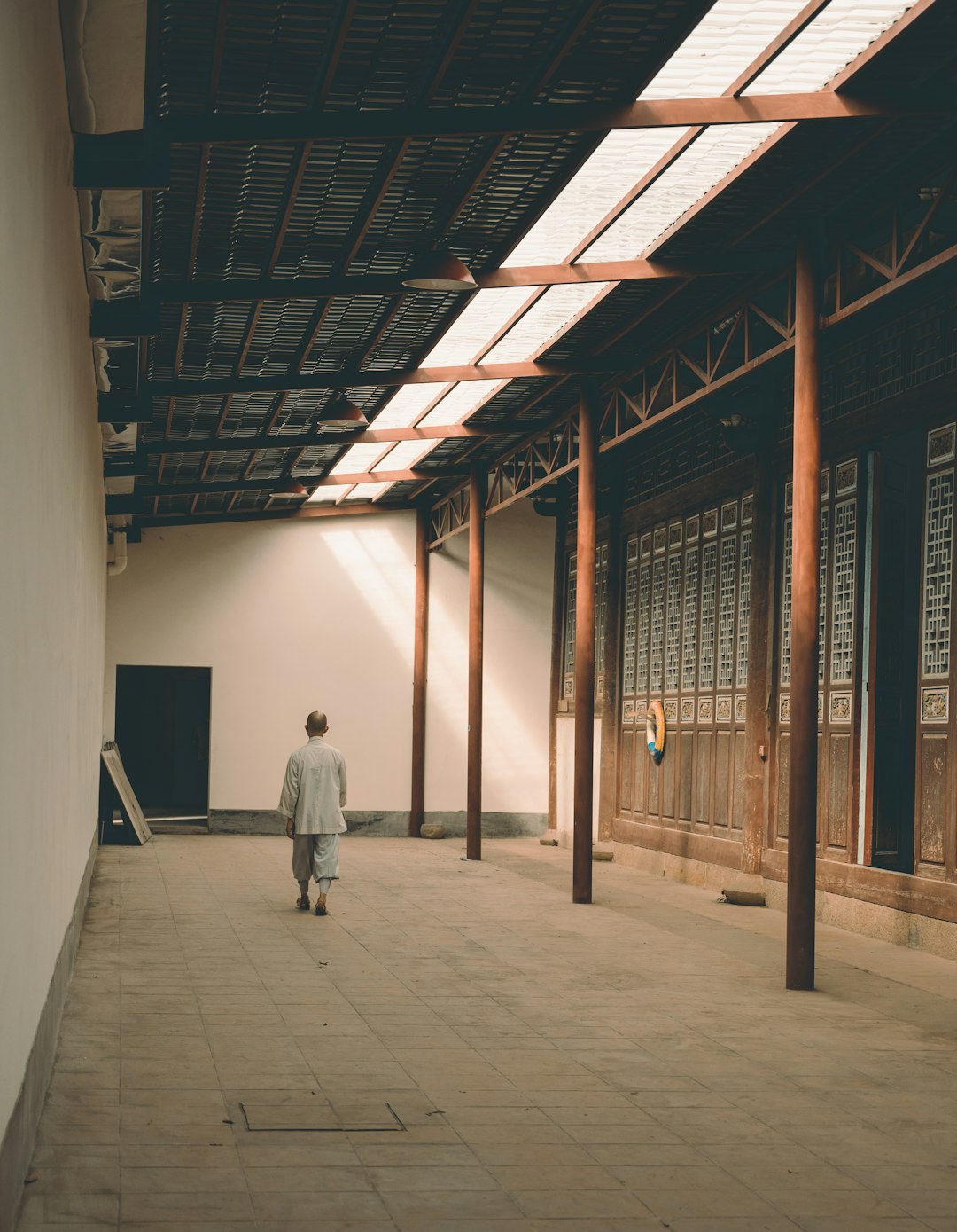 man in white robe walking on hallway