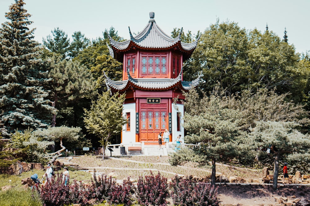 red and white concrete building surrounded by green trees during daytime