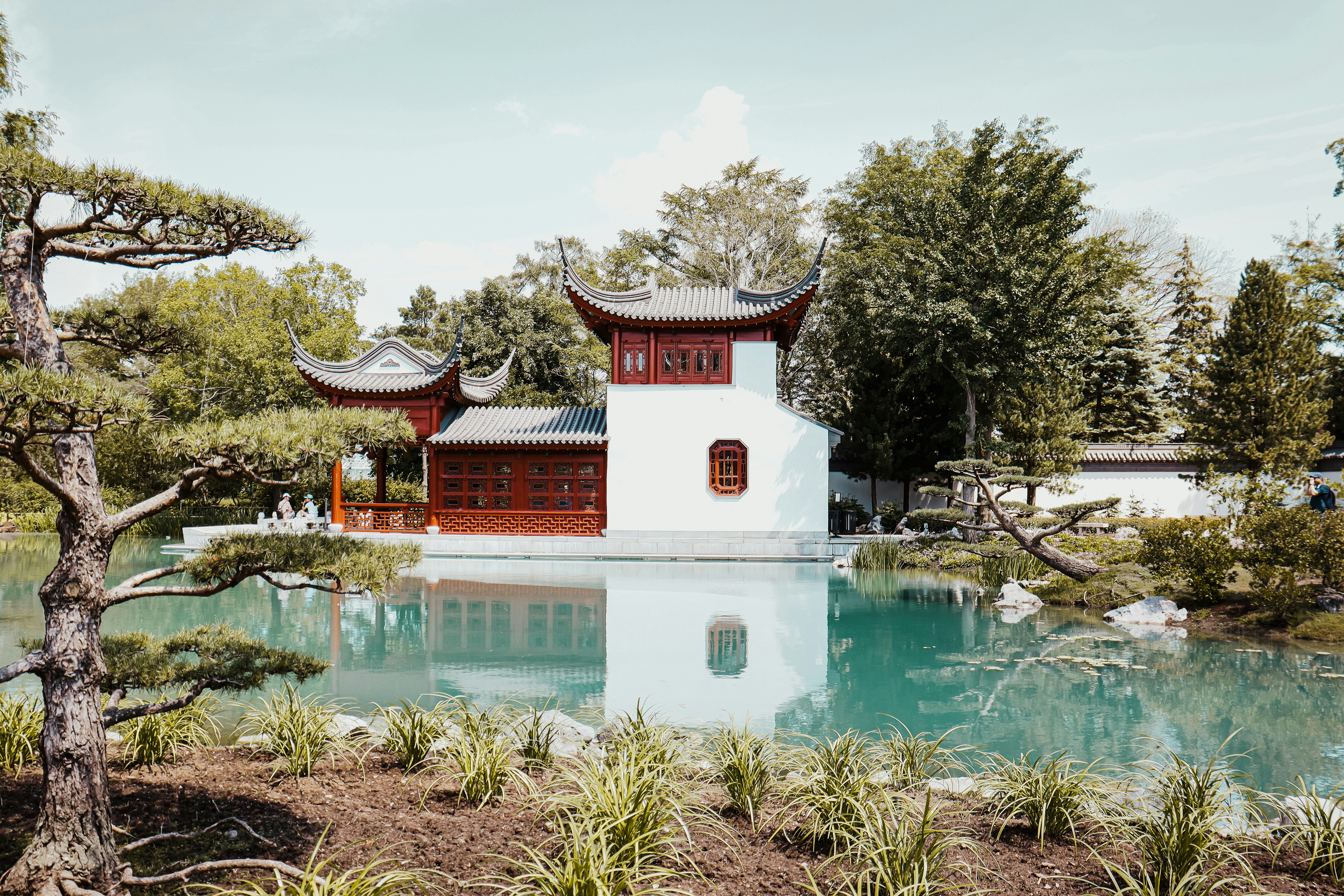 white and red concrete building near body of water during daytime