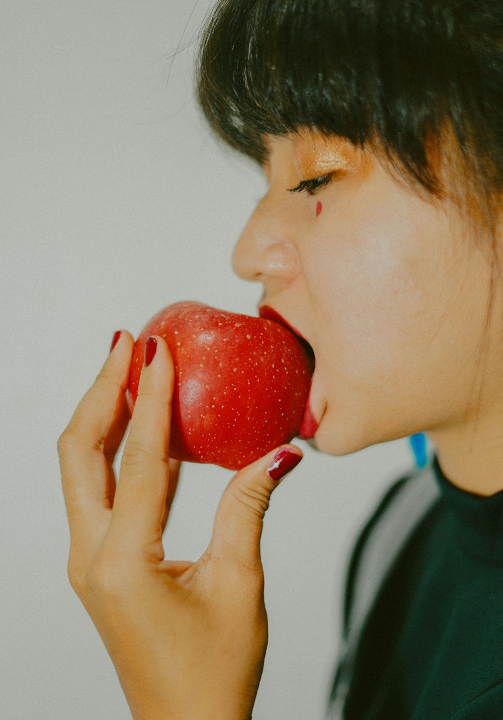 boy in black crew neck shirt holding red apple