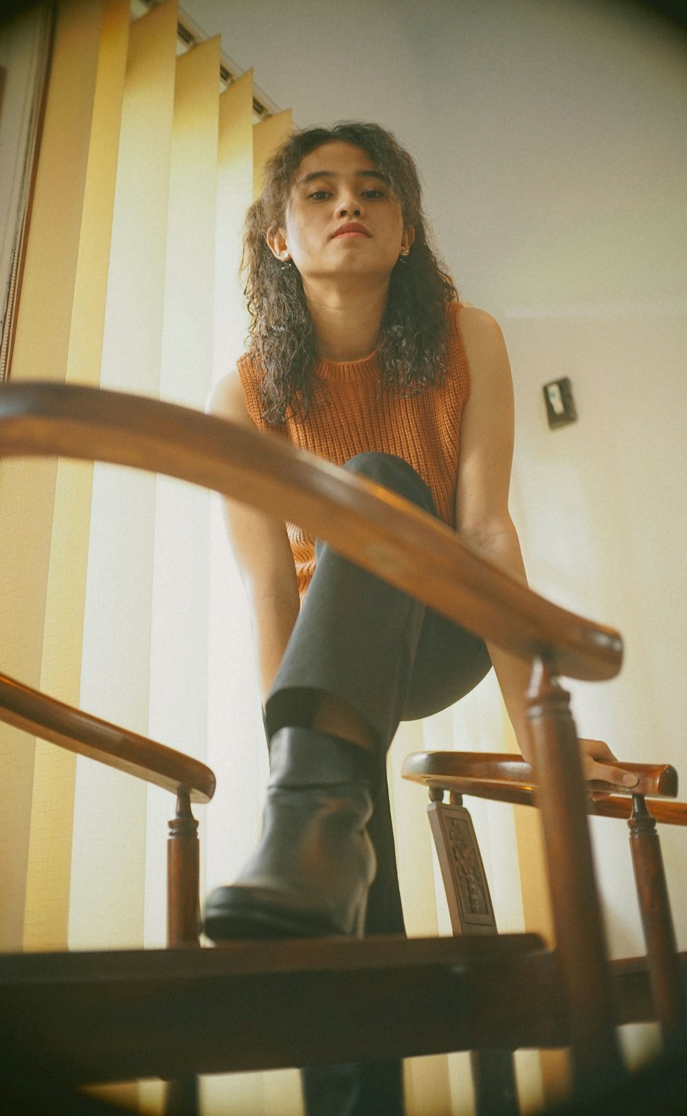 woman in black tank top and black pants sitting on brown wooden chair