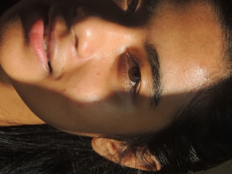 Close-up of a smooth, radiant face glowing under soft light.