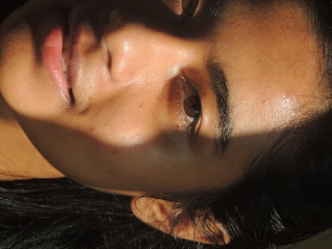 Close-up of a smooth, radiant face glowing under soft light.