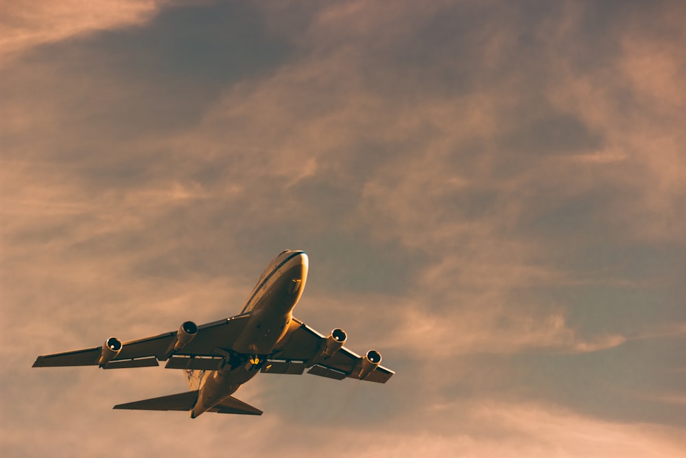 white and black airplane under cloudy sky during daytime