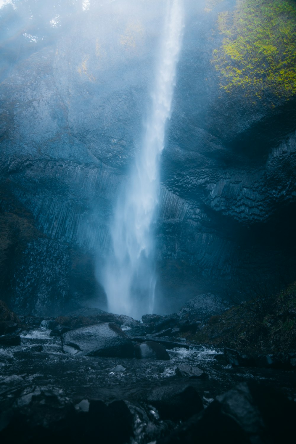 water falls on rocky shore during daytime