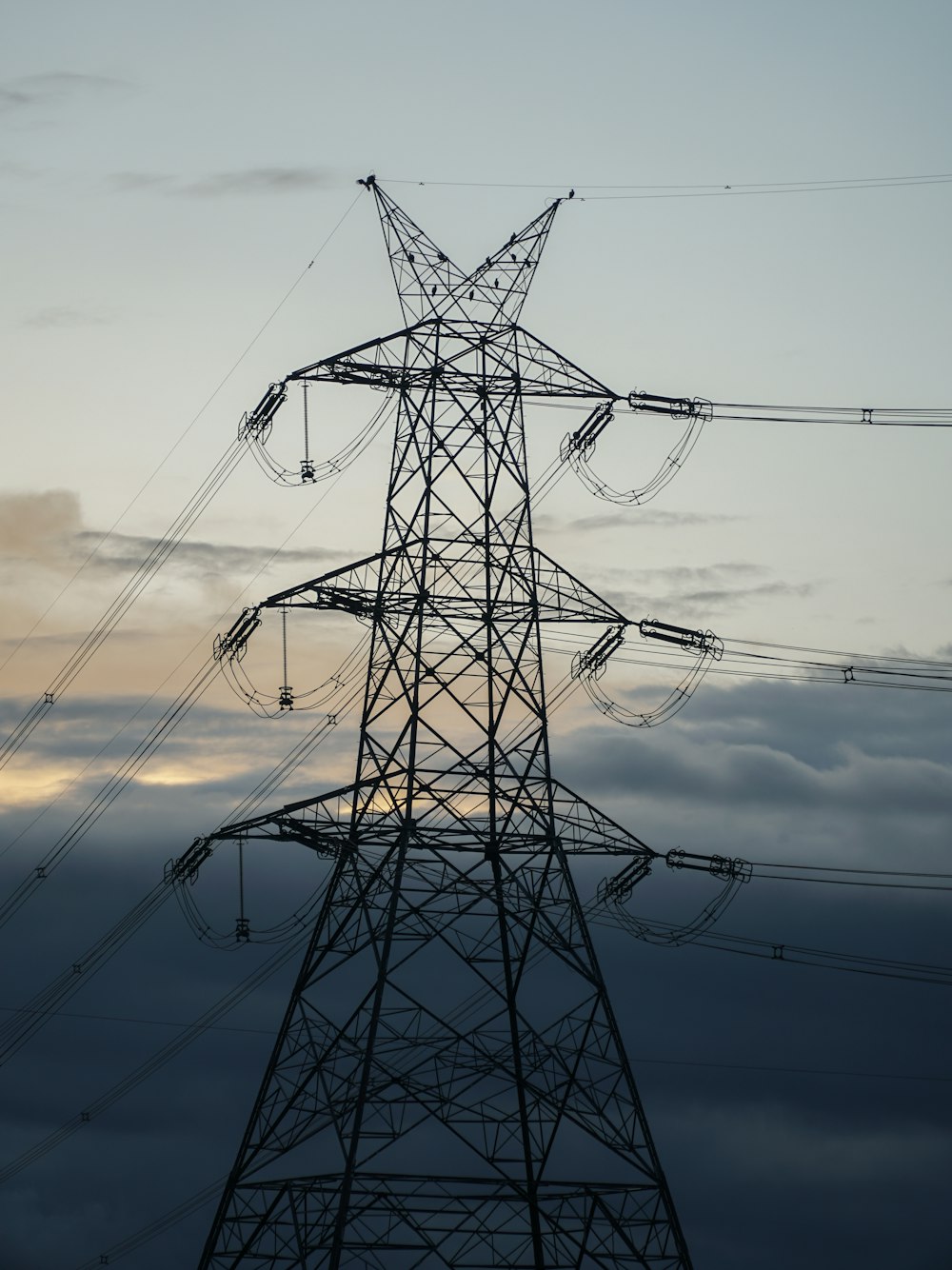 black electric post under cloudy sky during daytime