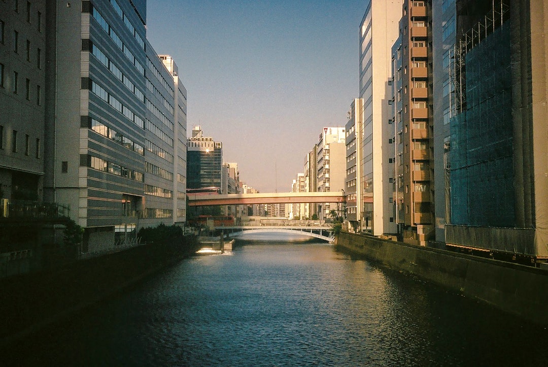 white and brown concrete building near river during daytime