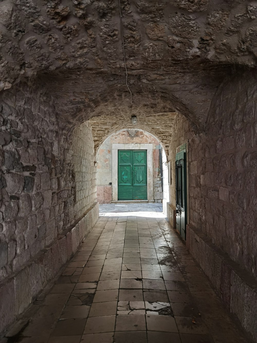 brown brick hallway with blue wooden door