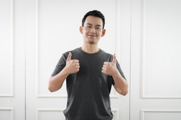 man in black tank top standing near white wall