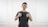 man in black tank top standing near white wall