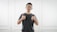 man in black tank top standing near white wall